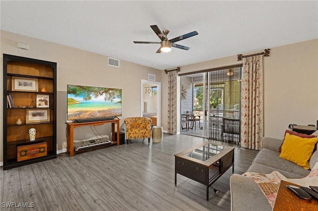 living area featuring wood finished floors, visible vents, and a ceiling fan