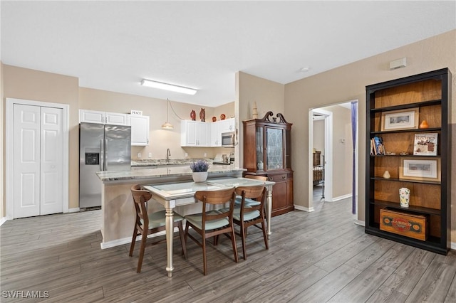 dining room with light wood-type flooring and baseboards