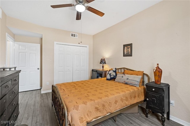 bedroom with a ceiling fan, visible vents, baseboards, a closet, and dark wood-style floors