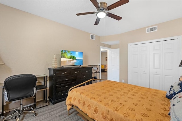 bedroom featuring light wood finished floors, a closet, visible vents, and a ceiling fan