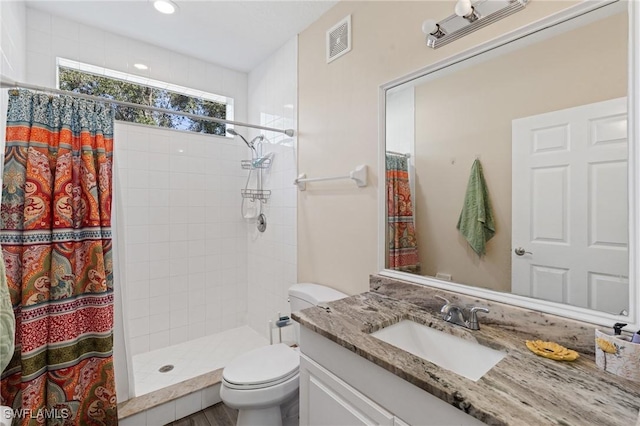 full bathroom featuring visible vents, a shower stall, toilet, and vanity