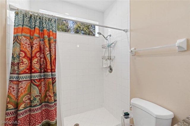 full bath with a tile shower and toilet