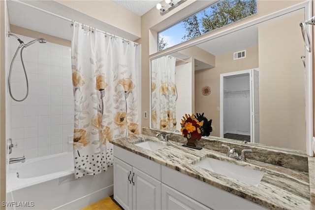 bathroom with double vanity, visible vents, a sink, and shower / bath combo with shower curtain