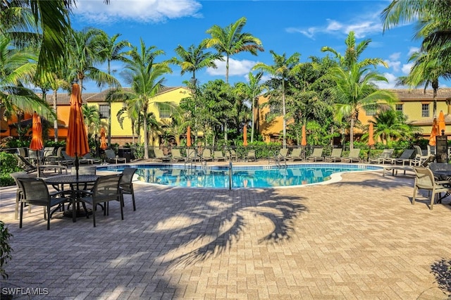 community pool with a patio and fence