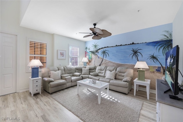 living room with light wood finished floors, baseboards, and a ceiling fan