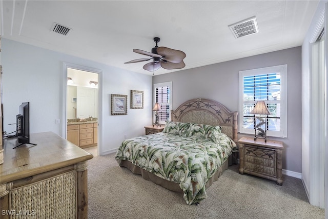 bedroom with light carpet, ensuite bathroom, visible vents, and baseboards