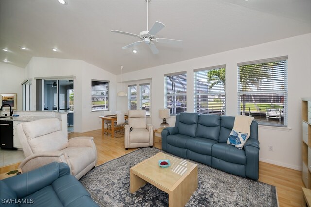 living area with light wood finished floors, vaulted ceiling, a ceiling fan, and recessed lighting