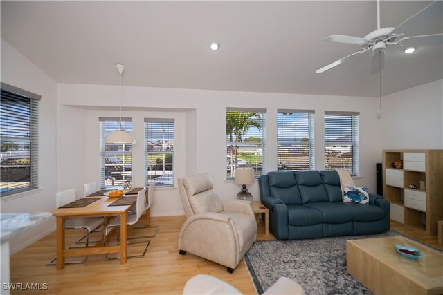 living room featuring light wood-type flooring, a ceiling fan, and baseboards