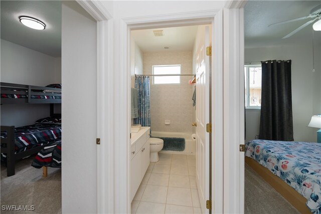 full bath with a ceiling fan, vanity, tile patterned floors, shower / bath combo, and a walk in closet