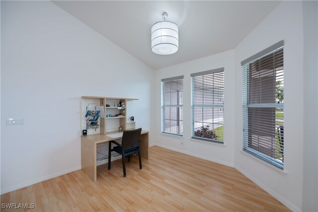 office area with lofted ceiling, baseboards, and wood finished floors