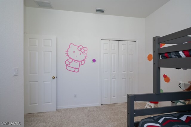 bedroom with carpet, visible vents, and a closet