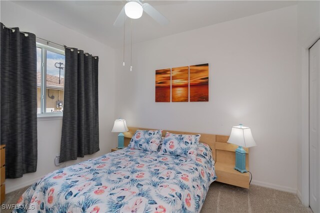 carpeted bedroom with ceiling fan and baseboards