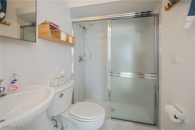 bathroom featuring a sink, a shower stall, and toilet