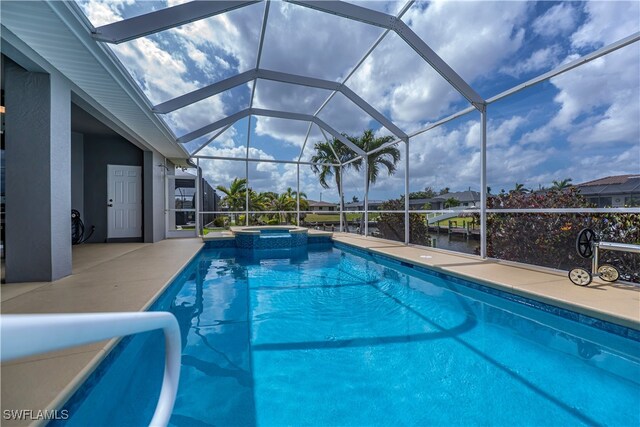 view of pool featuring a patio, a lanai, and a pool with connected hot tub