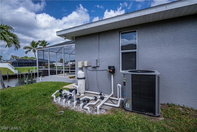 exterior space featuring a lanai, a lawn, cooling unit, and stucco siding