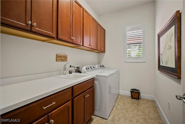 washroom featuring washer and clothes dryer, a sink, cabinet space, and baseboards