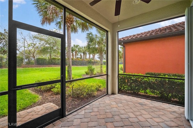 unfurnished sunroom with a wealth of natural light and ceiling fan