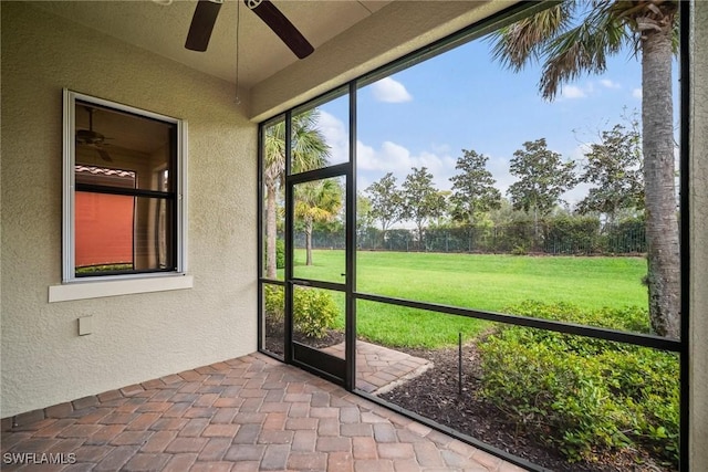 unfurnished sunroom with a ceiling fan