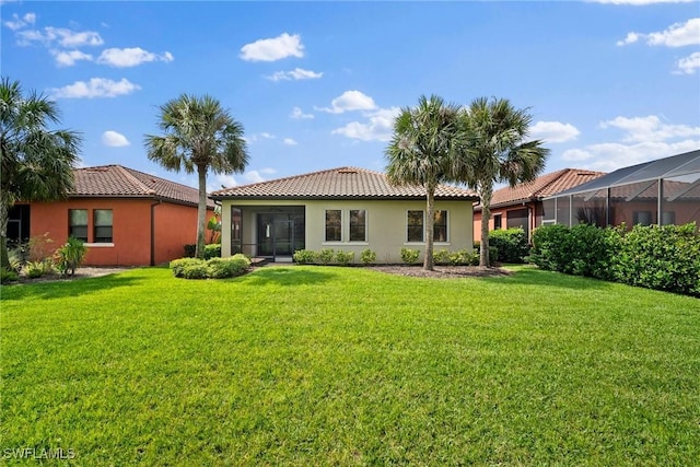 back of property featuring a tiled roof, a lawn, and stucco siding