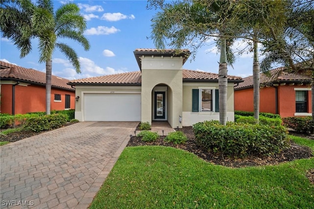 mediterranean / spanish-style home featuring decorative driveway, a tiled roof, an attached garage, and stucco siding