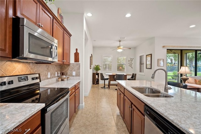 kitchen with stainless steel appliances, a healthy amount of sunlight, a sink, and backsplash