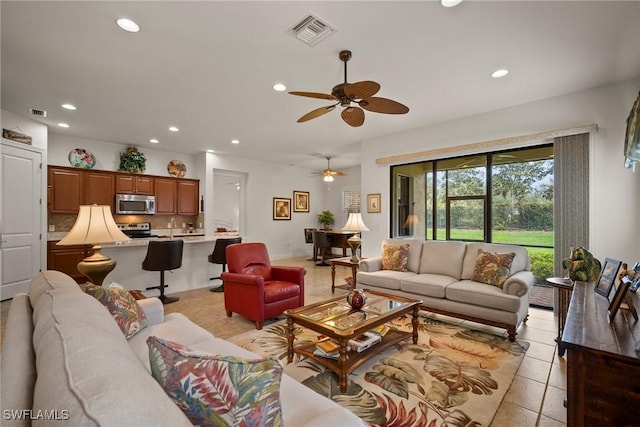 living area featuring light tile patterned floors, baseboards, visible vents, and recessed lighting