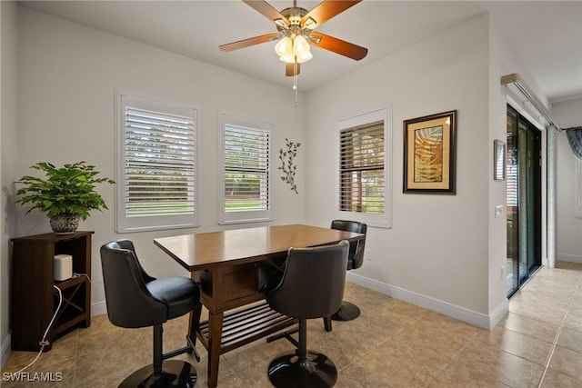 dining space featuring a ceiling fan and baseboards