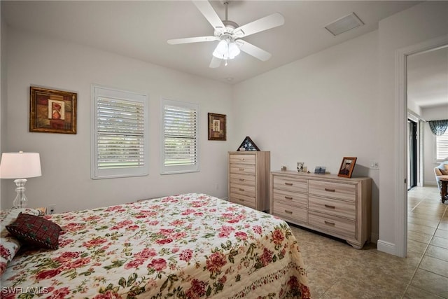 bedroom featuring visible vents, ceiling fan, baseboards, and light tile patterned floors