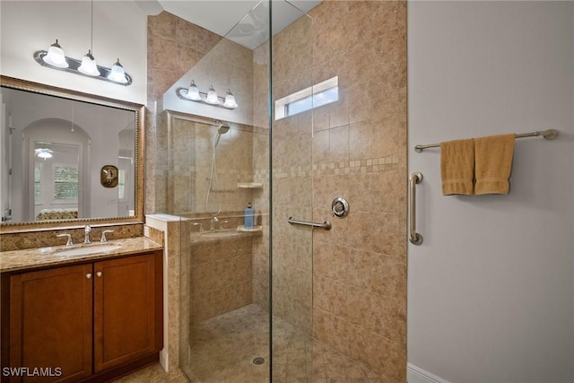 bathroom featuring a wealth of natural light, tiled shower, and vanity