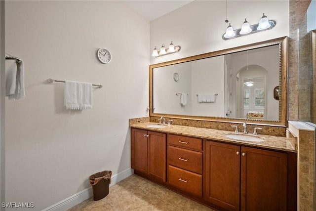 full bathroom with double vanity, tile patterned flooring, baseboards, and a sink