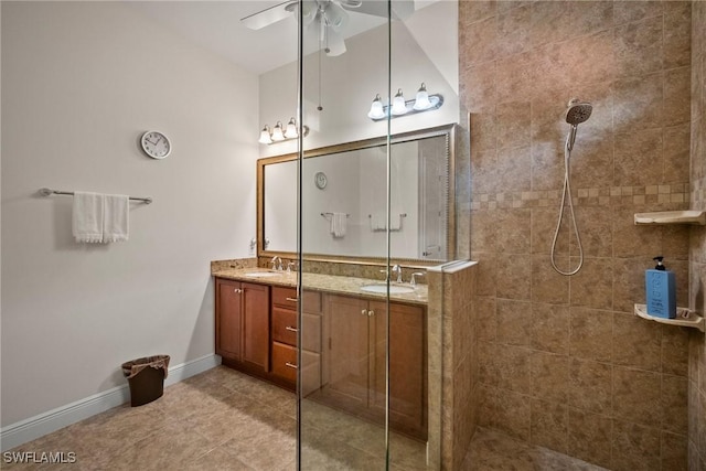 bathroom with walk in shower, a sink, baseboards, and double vanity