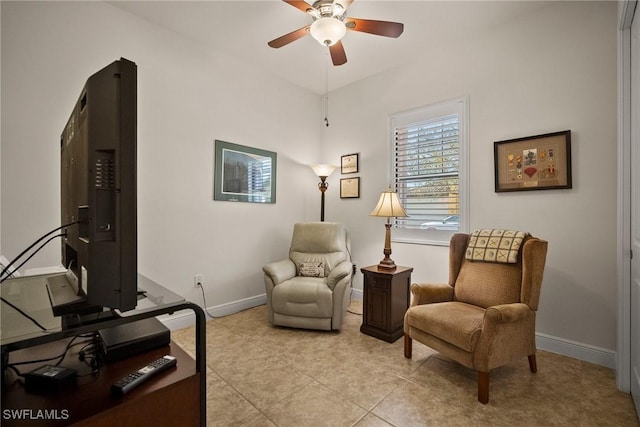 sitting room with a ceiling fan, baseboards, and light tile patterned floors