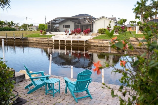 dock area featuring a patio area, glass enclosure, and a water view