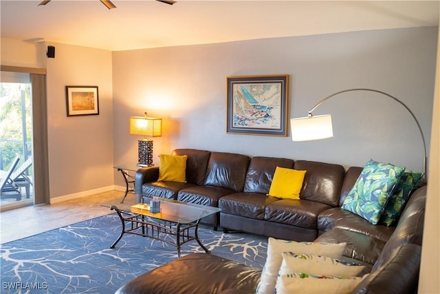 living room with ceiling fan and baseboards