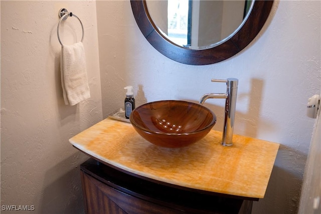 bathroom featuring a textured wall and vanity