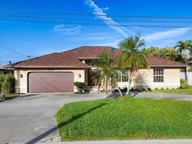 view of front of house featuring a garage, a front yard, driveway, and stucco siding