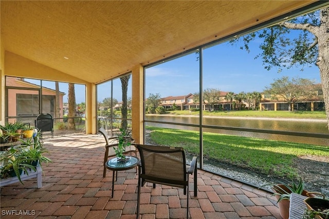 unfurnished sunroom with a water view and lofted ceiling