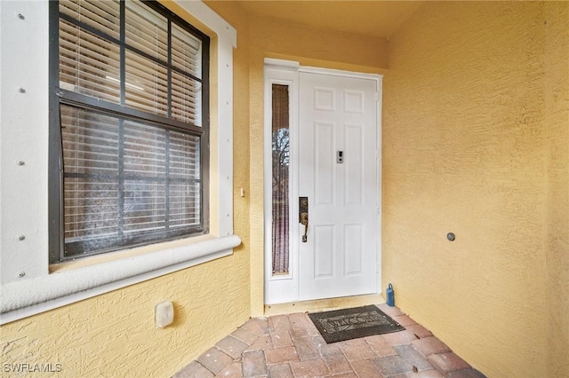 property entrance featuring stucco siding