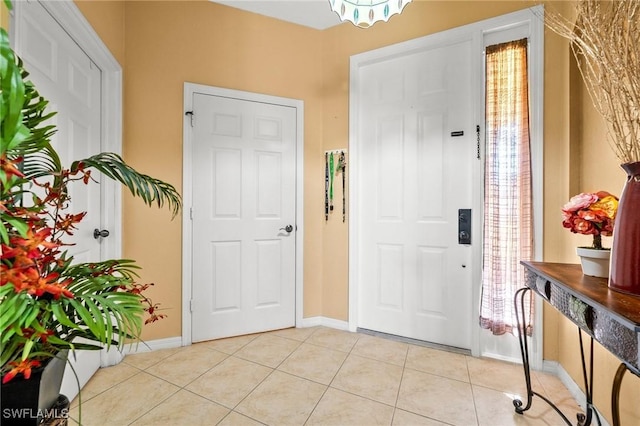 foyer entrance featuring baseboards and light tile patterned floors