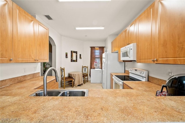 kitchen featuring arched walkways, light countertops, visible vents, a sink, and white appliances