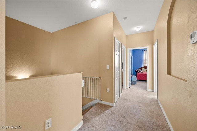 hallway with baseboards and carpet flooring