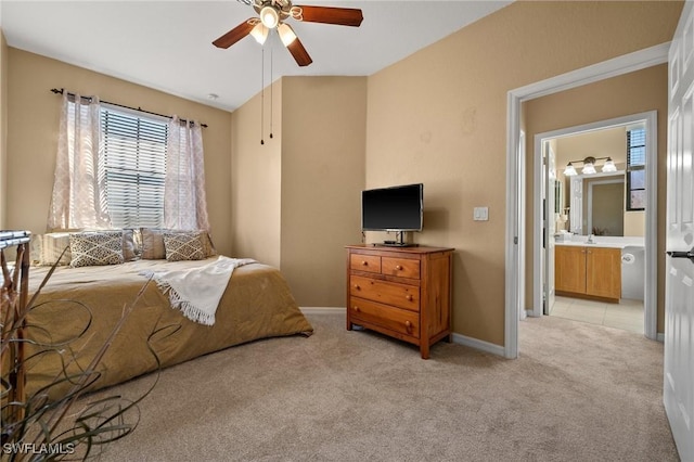 bedroom featuring light carpet, a sink, baseboards, and a ceiling fan