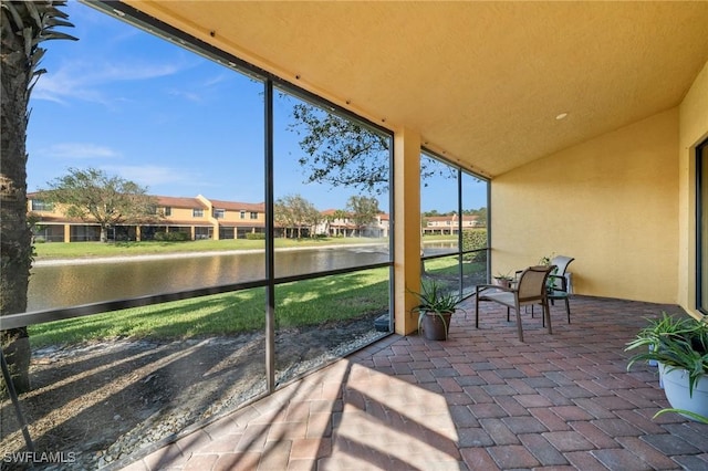 sunroom with a water view and lofted ceiling