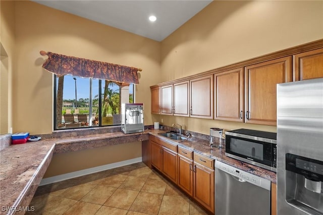 kitchen with light tile patterned floors, brown cabinets, stainless steel appliances, a sink, and recessed lighting