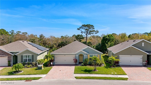 18512 Marlin Kite Ln, North Fort Myers, FL 33917 - ranch-style home featuring an attached garage, solar panels, decorative driveway, and a front yard