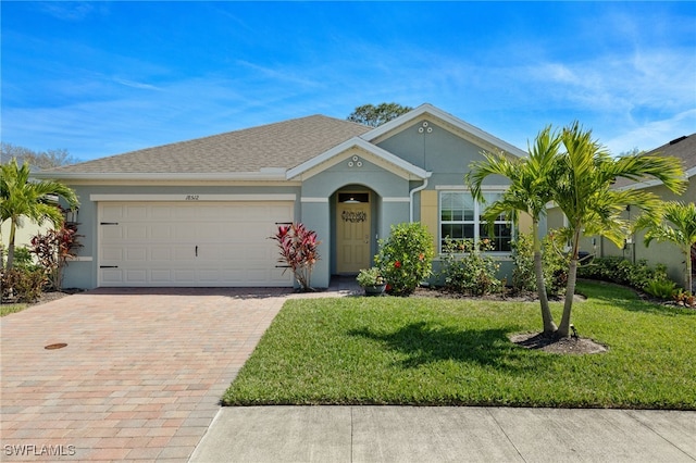 single story home with a garage, a shingled roof, decorative driveway, stucco siding, and a front yard