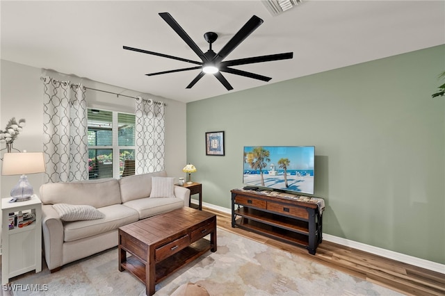 living room featuring visible vents, ceiling fan, light wood-style flooring, and baseboards