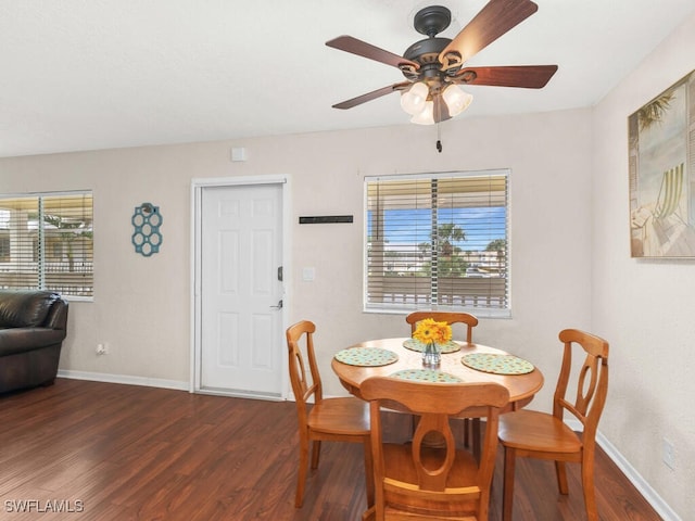 dining room featuring dark wood-type flooring, a wealth of natural light, baseboards, and a ceiling fan