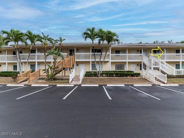 view of property featuring uncovered parking and stairway