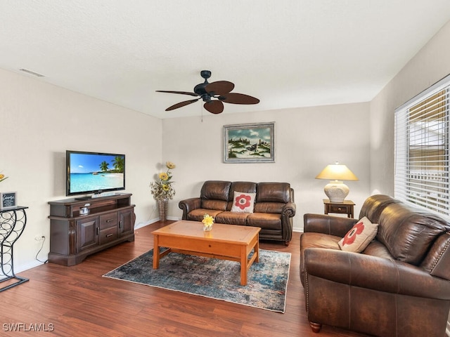 living area with a ceiling fan, baseboards, visible vents, and wood finished floors